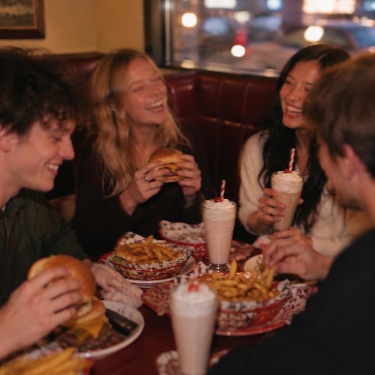 Friends sharing burgers and shakes